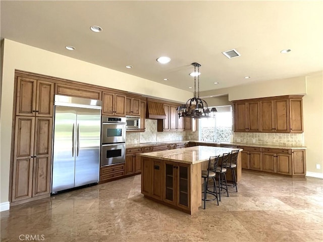 2068 Radnor Ave, Long Beach, CA 90815 - kitchen with built in appliances, a kitchen island, decorative backsplash, premium range hood, and light stone counters