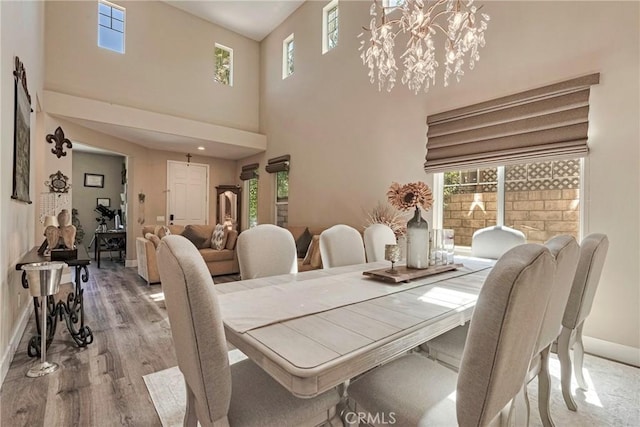 19639 Ellis Henry Ct, Newhall, CA 91321 - dining room featuring wood finished floors, a high ceiling, and a chandelier
