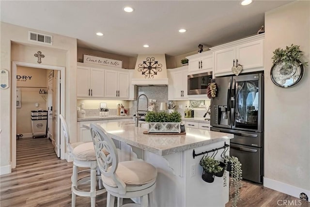 19639 Ellis Henry Ct, Newhall, CA 91321 - kitchen with fridge with ice dispenser, stainless steel microwave, white cabinets, recessed lighting, and light wood-type flooring