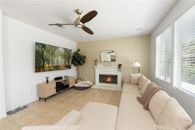 1182 Chenin Blanc Cir, Perris, CA 92571 - living area featuring light tile patterned floors, a glass covered fireplace, and a ceiling fan