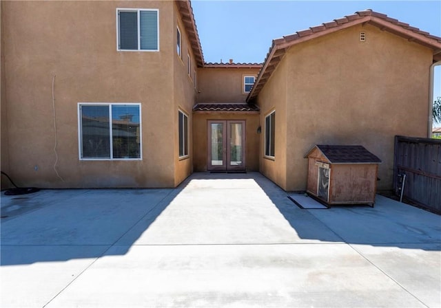 1182 Chenin Blanc Cir, Perris, CA 92571 - rear view of house featuring french doors, stucco siding, a patio area, a storage unit, and a tiled roof