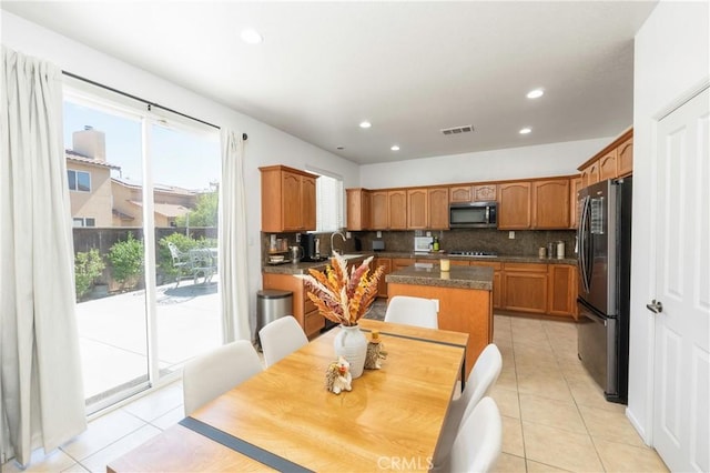 1182 Chenin Blanc Cir, Perris, CA 92571 - kitchen featuring stainless steel microwave, freestanding refrigerator, decorative backsplash, light tile patterned flooring, and recessed lighting
