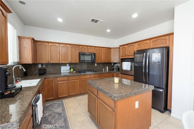 1182 Chenin Blanc Cir, Perris, CA 92571 - kitchen with black appliances, brown cabinets, a center island, backsplash, and recessed lighting