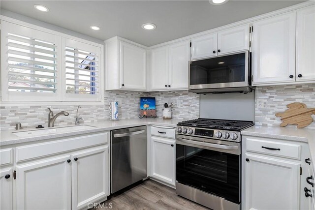 309 Sequoia St Unit 3, Morro Bay, CA 93442 - kitchen with stainless steel appliances, white cabinets, light countertops, decorative backsplash, and recessed lighting