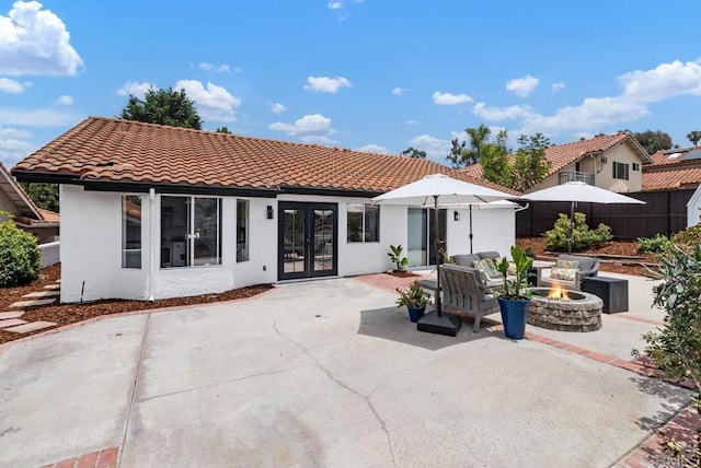 2663 Sutter St, Carlsbad, CA 92010 - back of property featuring french doors, an outdoor fire pit, a patio, a tiled roof, and stucco siding