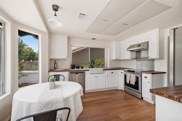 2663 Sutter St, Carlsbad, CA 92010 - kitchen with appliances with stainless steel finishes, butcher block countertops, under cabinet range hood, and white cabinets