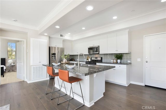 402 Maravilla Ln, Brea, CA 92823 - kitchen featuring stainless steel appliances, crown molding, dark wood-type flooring, a breakfast bar, and decorative backsplash
