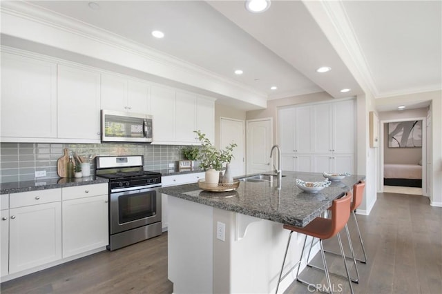 402 Maravilla Ln, Brea, CA 92823 - kitchen with stainless steel appliances, crown molding, dark wood finished floors, backsplash, and a breakfast bar