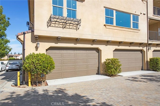 402 Maravilla Ln, Brea, CA 92823 - view of property exterior with a garage, stucco siding, and decorative driveway