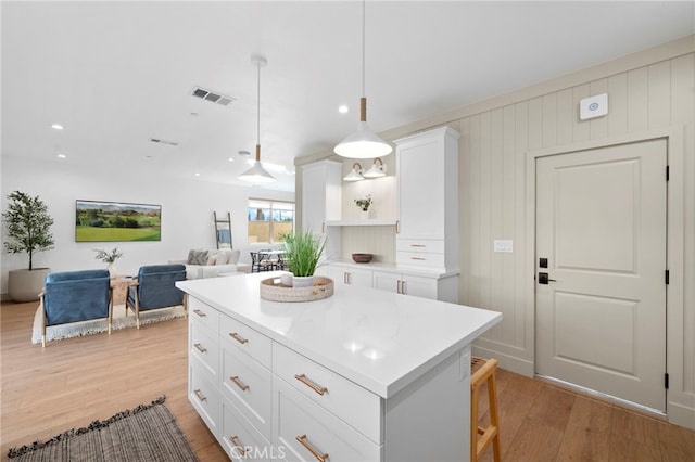 16229 Orizaba Ave, Paramount, CA 90723 - kitchen with light wood-style flooring, open shelves, white cabinetry, light countertops, and a center island