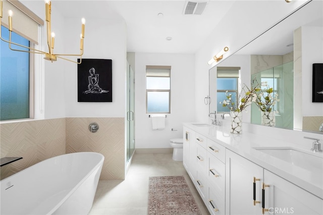 16229 Orizaba Ave, Paramount, CA 90723 - full bathroom featuring double vanity, a freestanding bath, a shower stall, wainscoting, and tile walls