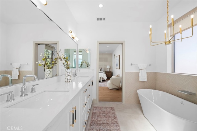 16229 Orizaba Ave, Paramount, CA 90723 - ensuite bathroom with a freestanding bath, double vanity, tile walls, wainscoting, and tile patterned floors