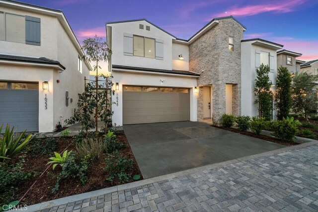 16229 Orizaba Ave, Paramount, CA 90723 - view of front facade with driveway, an attached garage, stucco siding, and stone siding