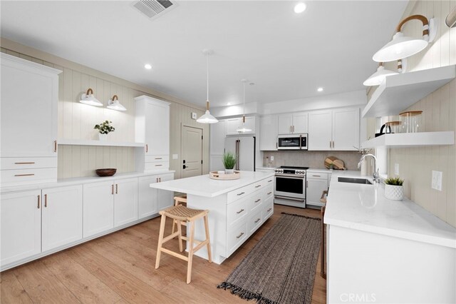 16229 Orizaba Ave, Paramount, CA 90723 - kitchen featuring open shelves, white electric range oven, freestanding refrigerator, a kitchen island, and white cabinetry