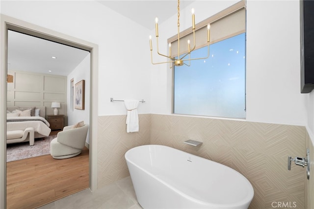 16229 Orizaba Ave, Paramount, CA 90723 - ensuite bathroom featuring a soaking tub, a chandelier, and a wainscoted wall