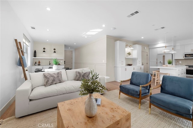 16229 Orizaba Ave, Paramount, CA 90723 - living area featuring light wood-style flooring, wainscoting, and recessed lighting