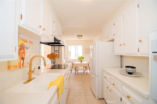 8710 Delgany Ave Unit 15, Playa Del Rey, CA 90293 - kitchen featuring under cabinet range hood, freestanding refrigerator, white cabinetry, light countertops, and light tile patterned floors