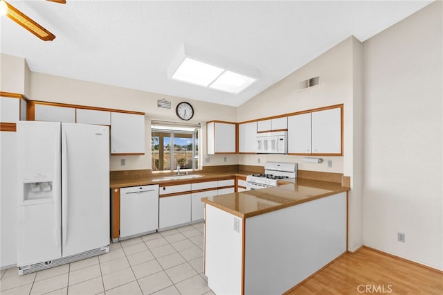 26293 Potomac Dr, Menifee, CA 92586 - kitchen with white appliances, white cabinets, a peninsula, lofted ceiling, and dark countertops