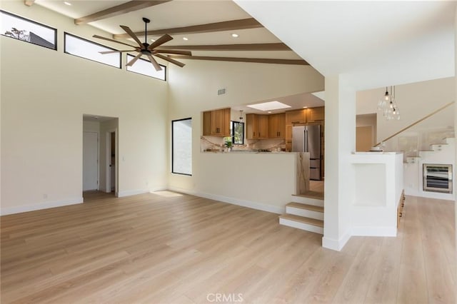 34693 Camino Capistrano Unit B, Dana Point, CA 92624 - unfurnished living room with a ceiling fan, wine cooler, beam ceiling, stairway, and light wood-type flooring