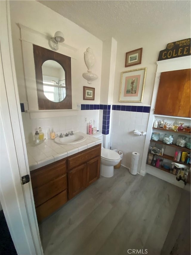 1210 7th Pl, Hermosa Beach, CA 90254 - bathroom featuring wood finished floors, vanity, a wainscoted wall, tile walls, and a textured ceiling