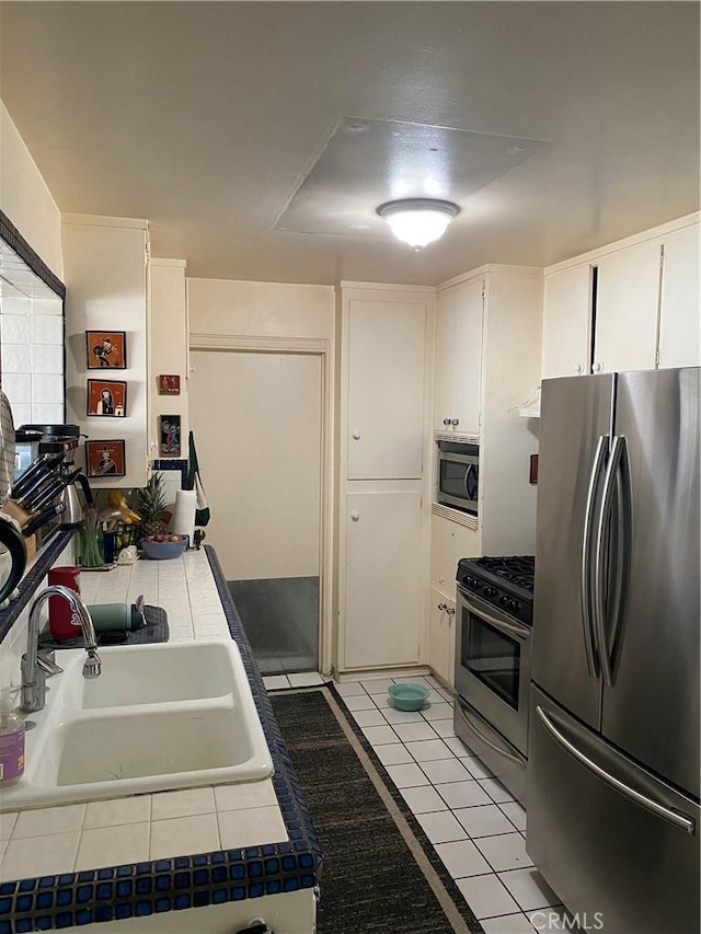 1210 7th Pl, Hermosa Beach, CA 90254 - kitchen featuring stainless steel appliances, tile countertops, white cabinets, and light tile patterned flooring