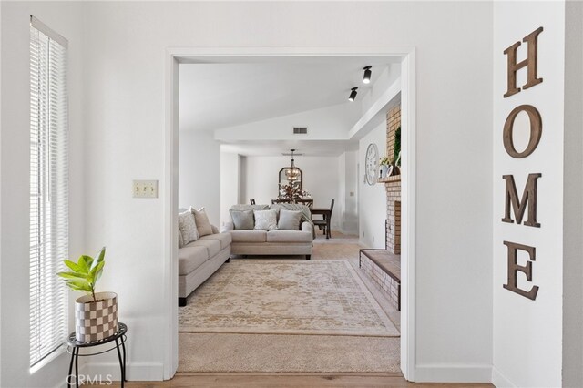 7009 Etter St, Bakersfield, CA 93308 - living room featuring lofted ceiling, healthy amount of natural light, and wood finished floors