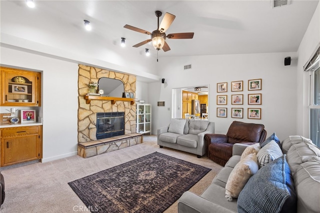 7009 Etter St, Bakersfield, CA 93308 - living room with light carpet, vaulted ceiling, a ceiling fan, and a fireplace