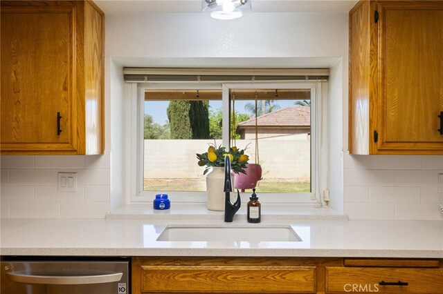 7009 Etter St, Bakersfield, CA 93308 - kitchen with dishwasher, brown cabinets, light countertops, and backsplash