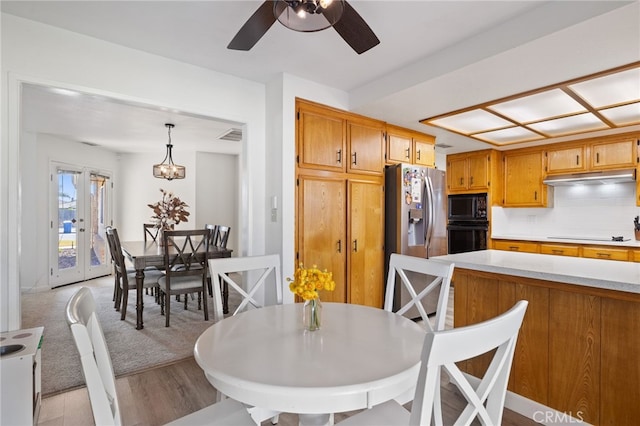 7009 Etter St, Bakersfield, CA 93308 - kitchen with black appliances, light wood-style flooring, light countertops, ceiling fan, and under cabinet range hood