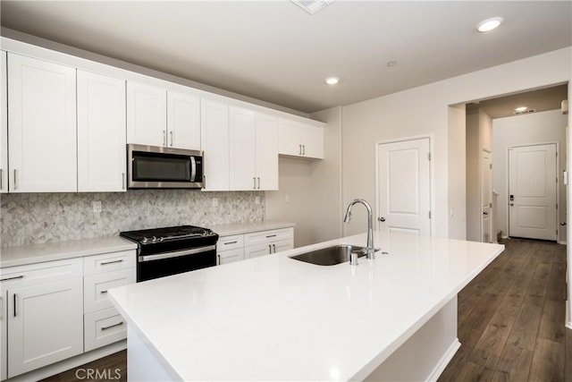 31844 Gimbal Way, Winchester, CA 92596 - kitchen featuring stainless steel microwave, gas stove, white cabinetry, an island with sink, and dark wood-type flooring