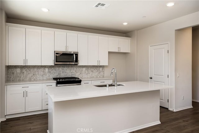 31844 Gimbal Way, Winchester, CA 92596 - kitchen with stainless steel microwave, range, dark wood-style floors, white cabinetry, and recessed lighting