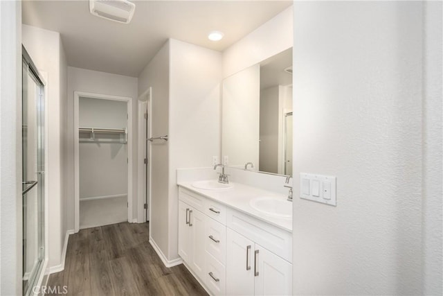 31844 Gimbal Way, Winchester, CA 92596 - bathroom with wood finished floors, a shower stall, a walk in closet, and double vanity