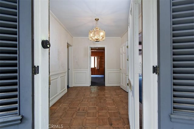 4312 Noble Ave, Sherman Oaks, CA 91403 - hall featuring a chandelier, a wainscoted wall, ornamental molding, and a decorative wall