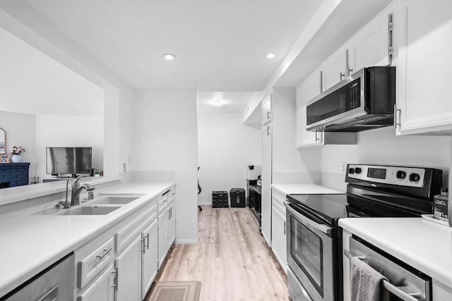 1040 E Washington Ave Unit 31, Escondido, CA 92025 - kitchen with stainless steel appliances, light countertops, white cabinets, light wood-type flooring, and recessed lighting
