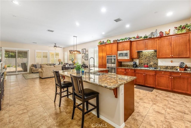 1506 Pierce Ml, Beaumont, CA 92223 - kitchen with stainless steel appliances, plenty of natural light, a kitchen breakfast bar, light stone countertops, and recessed lighting