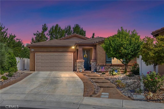1506 Pierce Ml, Beaumont, CA 92223 - view of front of house featuring a garage, driveway, stone siding, a tiled roof, and stucco siding