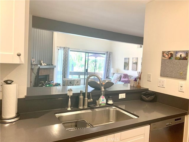 5800 Owensmouth Ave Unit 77, Woodland Hills, CA 91367 - kitchen featuring dark countertops, stainless steel dishwasher, and white cabinetry