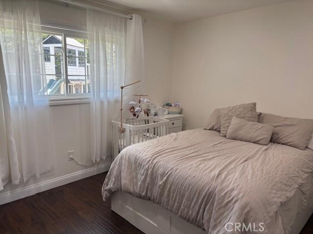 8596 Camelia Dr, Riverside, CA 92504 - bedroom featuring dark wood-style floors and baseboards