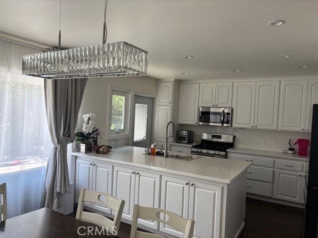 8596 Camelia Dr, Riverside, CA 92504 - kitchen with appliances with stainless steel finishes, white cabinets, light countertops, recessed lighting, and a peninsula