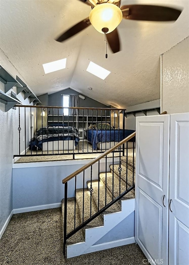12164 Galaxy St, Victorville, CA 92392 - stairs with vaulted ceiling, a skylight, a ceiling fan, and carpet flooring