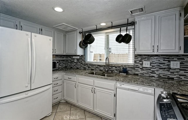 12164 Galaxy St, Victorville, CA 92392 - kitchen featuring white appliances, tasteful backsplash, a textured ceiling, light tile patterned flooring, and dark stone countertops