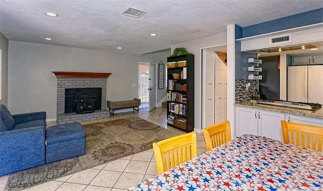12164 Galaxy St, Victorville, CA 92392 - living area featuring light tile patterned floors, a textured ceiling, a wood stove, and recessed lighting