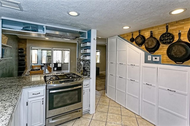 12164 Galaxy St, Victorville, CA 92392 - kitchen featuring stainless steel gas range oven, white cabinetry, light tile patterned floors, light stone counters, and a textured ceiling