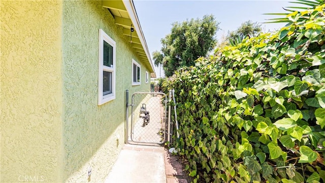 480 W D St, Colton, CA 92324 - view of side of home with stucco siding and a gate