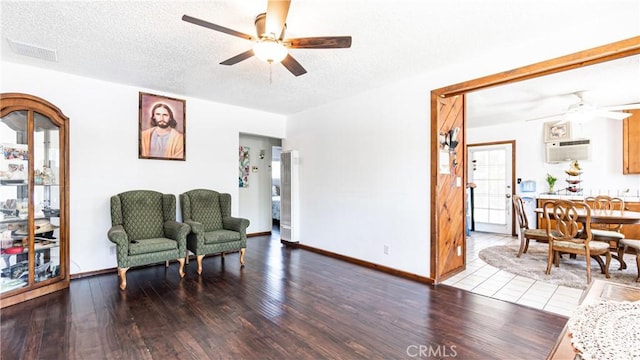 480 W D St, Colton, CA 92324 - living area featuring ceiling fan, wood finished floors, a wall unit AC, and a textured ceiling