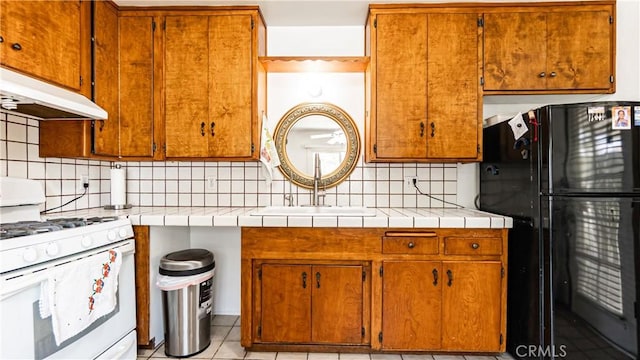480 W D St, Colton, CA 92324 - kitchen with white gas range, freestanding refrigerator, extractor fan, decorative backsplash, and light countertops