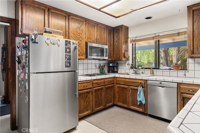 625 La Bonita Ct, Chico, CA 95973 - kitchen featuring appliances with stainless steel finishes, backsplash, tile counters, and brown cabinetry