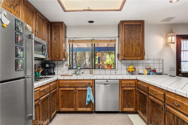 625 La Bonita Ct, Chico, CA 95973 - kitchen with stainless steel appliances, tasteful backsplash, brown cabinets, and recessed lighting