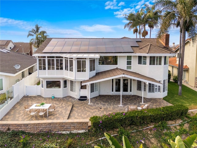 609 Calle Reata, San Clemente, CA 92673 - rear view of property with a sunroom, a patio, solar panels, a fenced backyard, and a standing seam roof