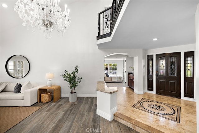 609 Calle Reata, San Clemente, CA 92673 - entrance foyer featuring arched walkways, a chandelier, recessed lighting, a towering ceiling, and wood finished floors